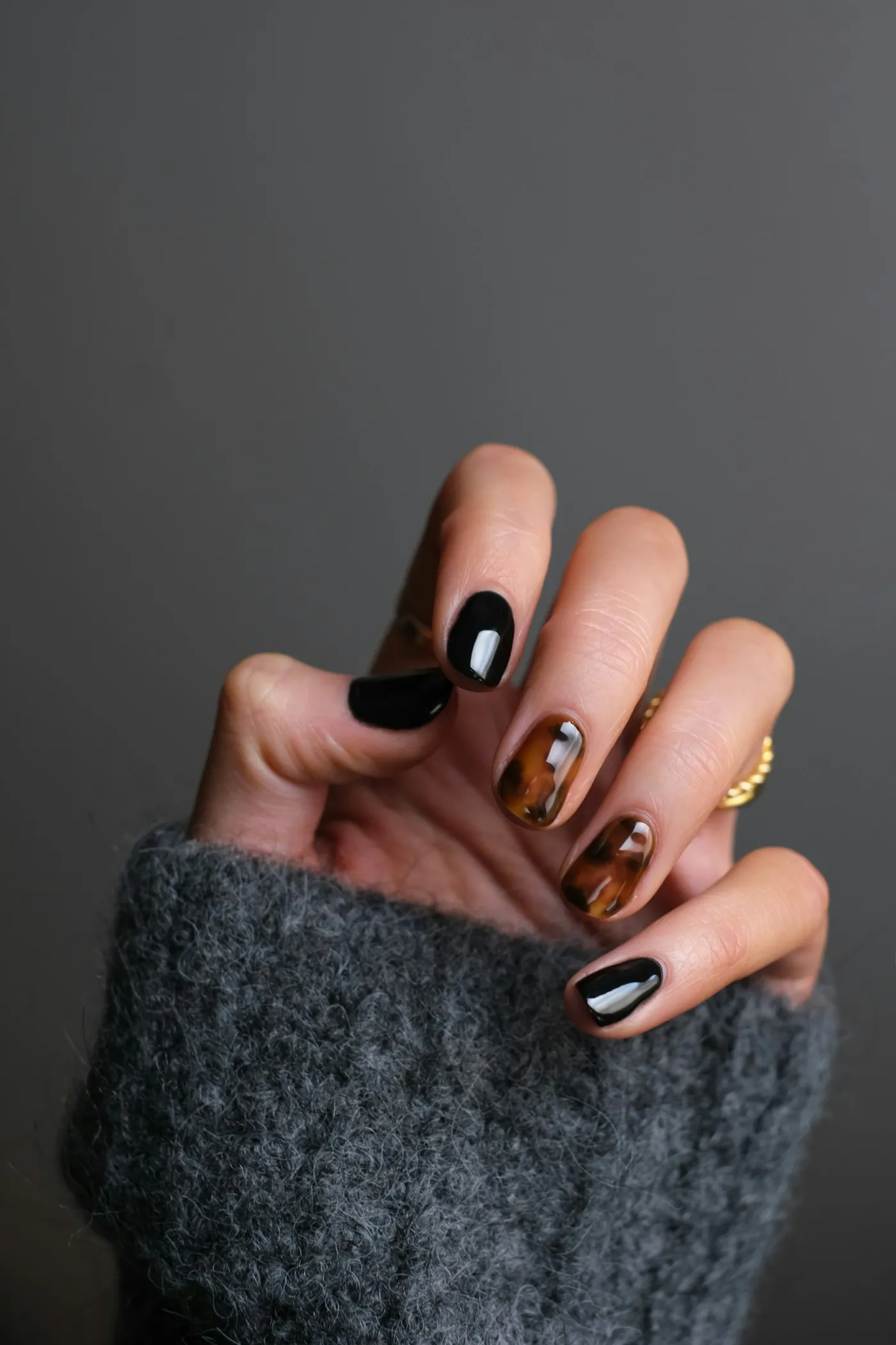 Close-up of a glossy pink manicure with detailed nail art in a bright salon setting.