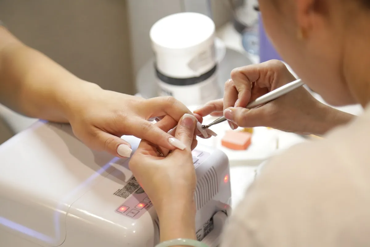Close-up of detailed nail art with soft neutral styling.